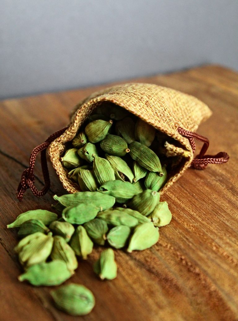 Green cardamom pods spilling from a burlap sack, the cool aromatic spice used in perfumery