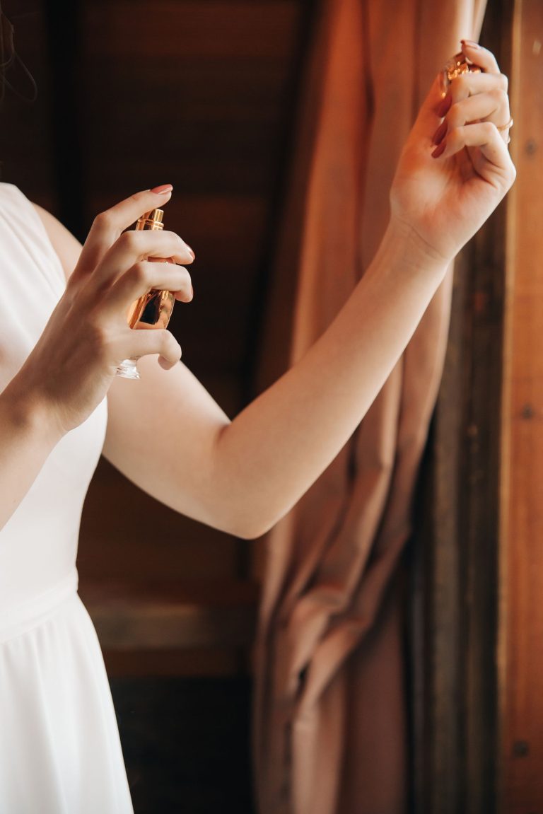 Woman applying and layering perfume on her wrist