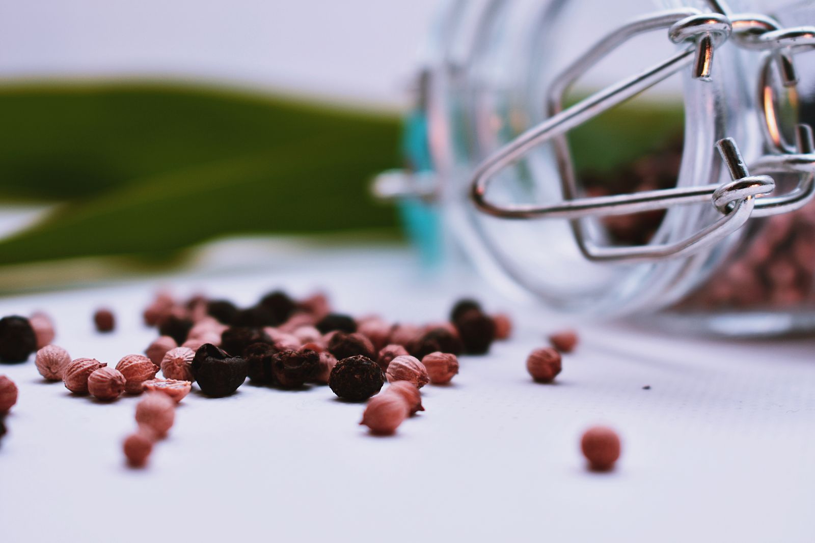 What Does Pepper Smell Like? Black, Pink & Beyond Black and pink peppercorns spilling from a jar, the source of pepper notes in perfumery