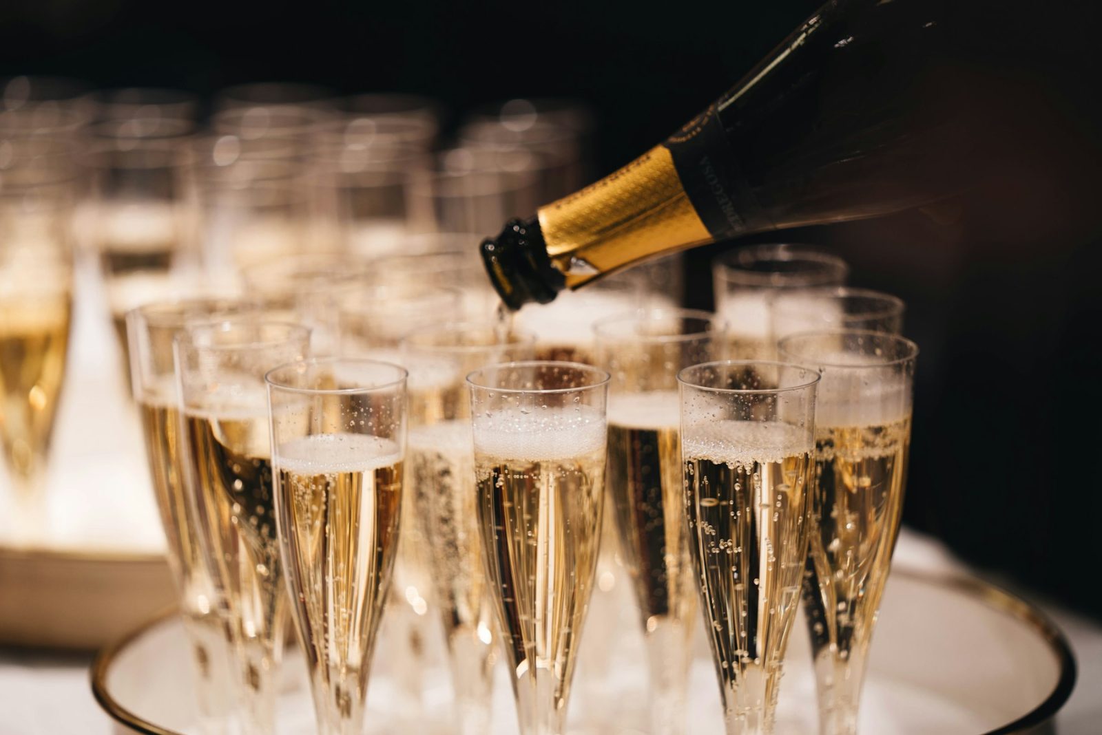 What Do Aldehydes Smell Like? Champagne poured into a row of flutes, illustrating the effervescent quality of aldehydes in perfume