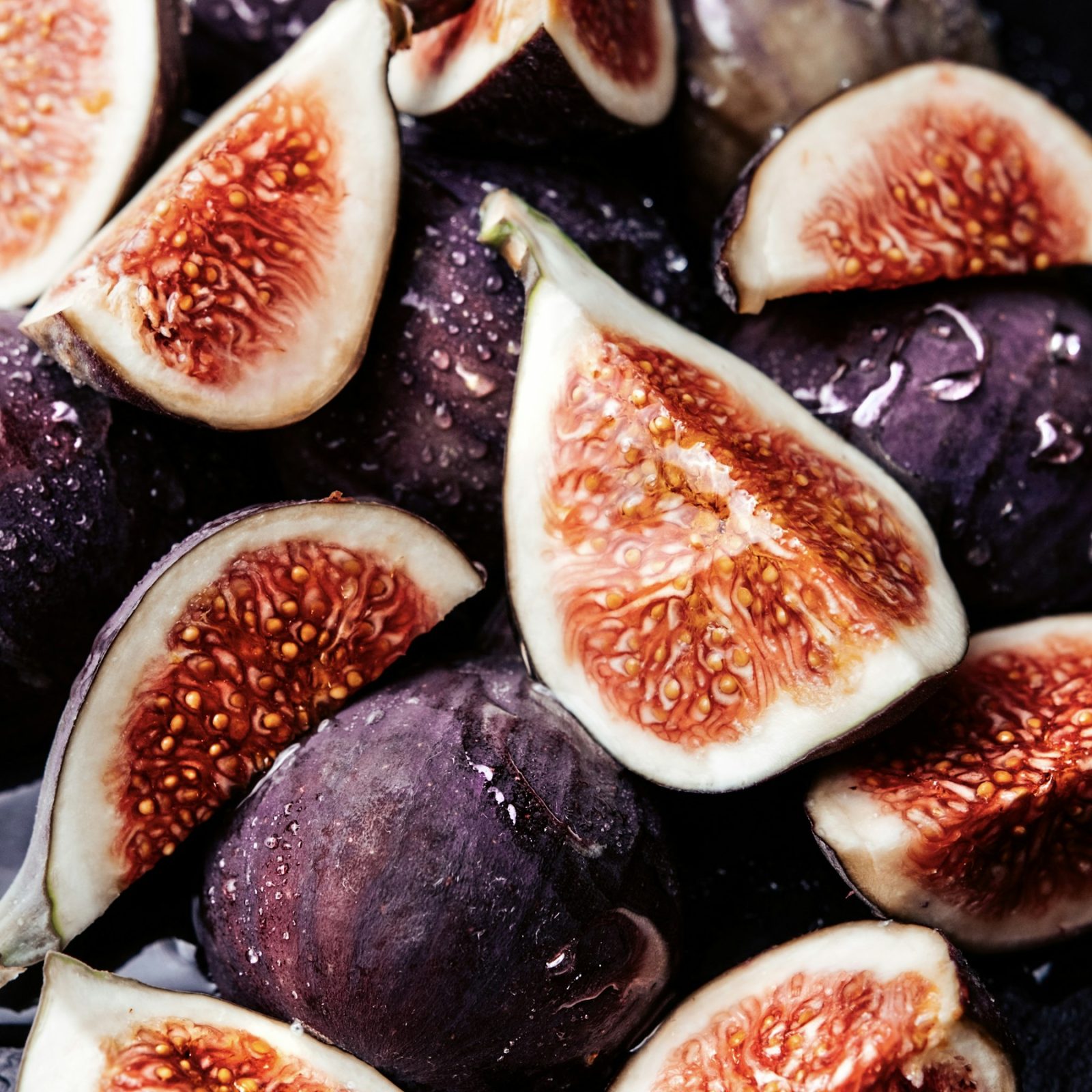 Fruity Fragrance Family: Notes, Scent Profile & History Fresh figs halved to show the seeded pink flesh, against a dark ground