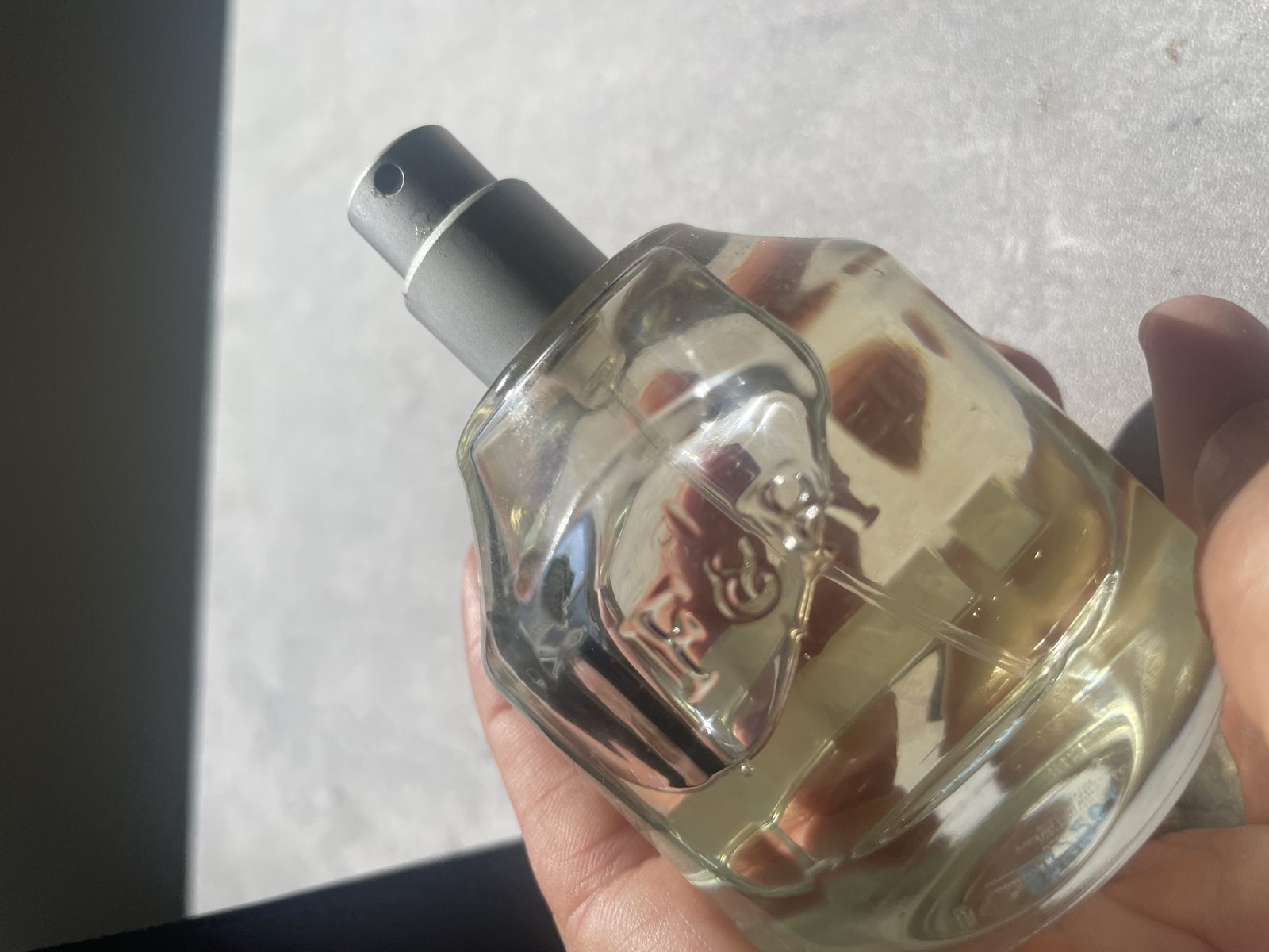 Fulton & Roark Cloudland Review: An Extrait That Won't Call Itself One Close-up through the clear faceted glass of Fulton & Roark Cloudland, the embossed monogram refracted