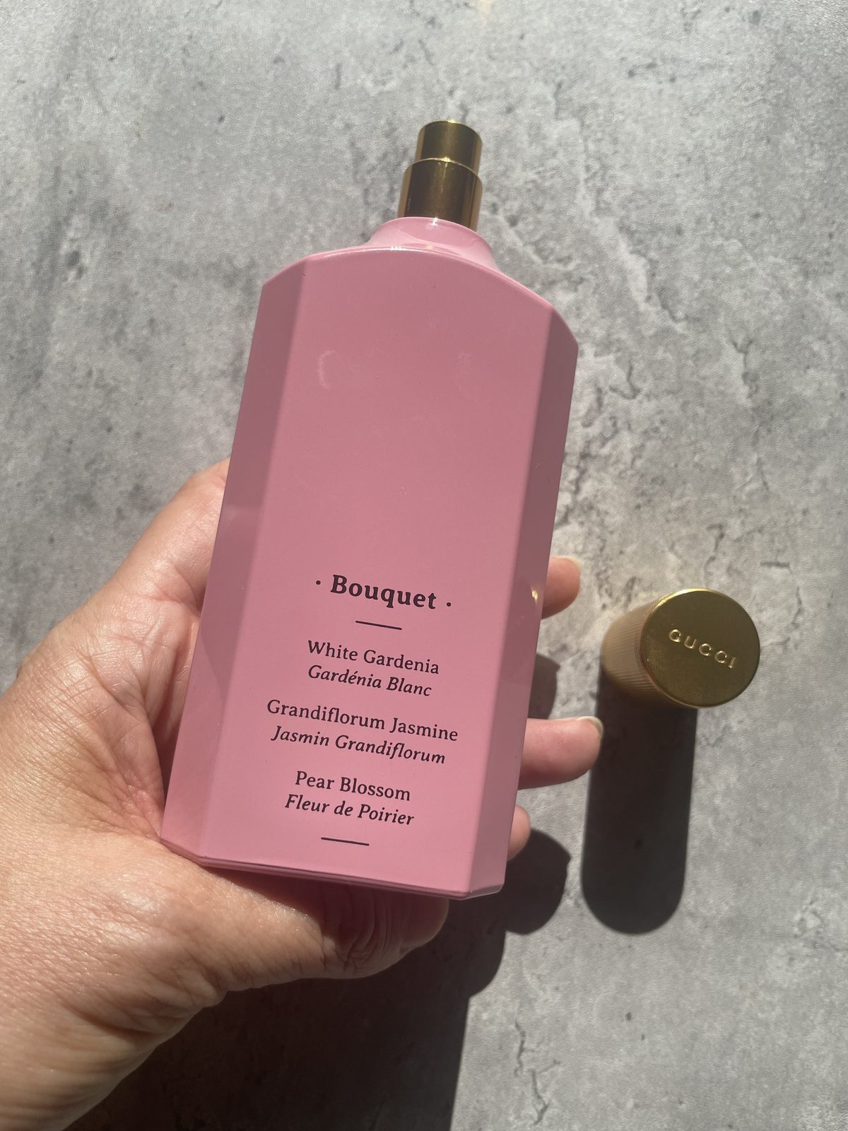 Gucci Flora Gorgeous Gardenia Review: The Flower That Isn't There Holding Gucci Flora Gorgeous Gardenia showing the bouquet panel: white gardenia, grandiflorum jasmine, pear blossom