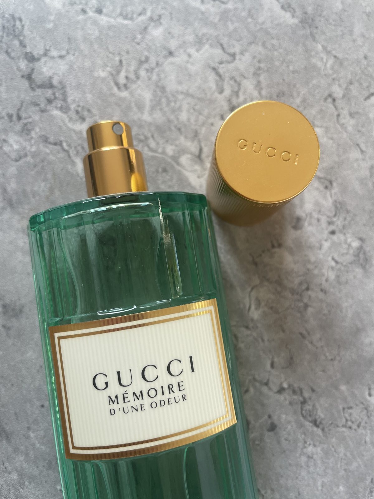 Gucci Memoire d’une Odeur EDP Review: Soothing & Soft Gucci Memoire d’une Odeur EDP with the cap off, showing the gold sprayer and fluted green glass