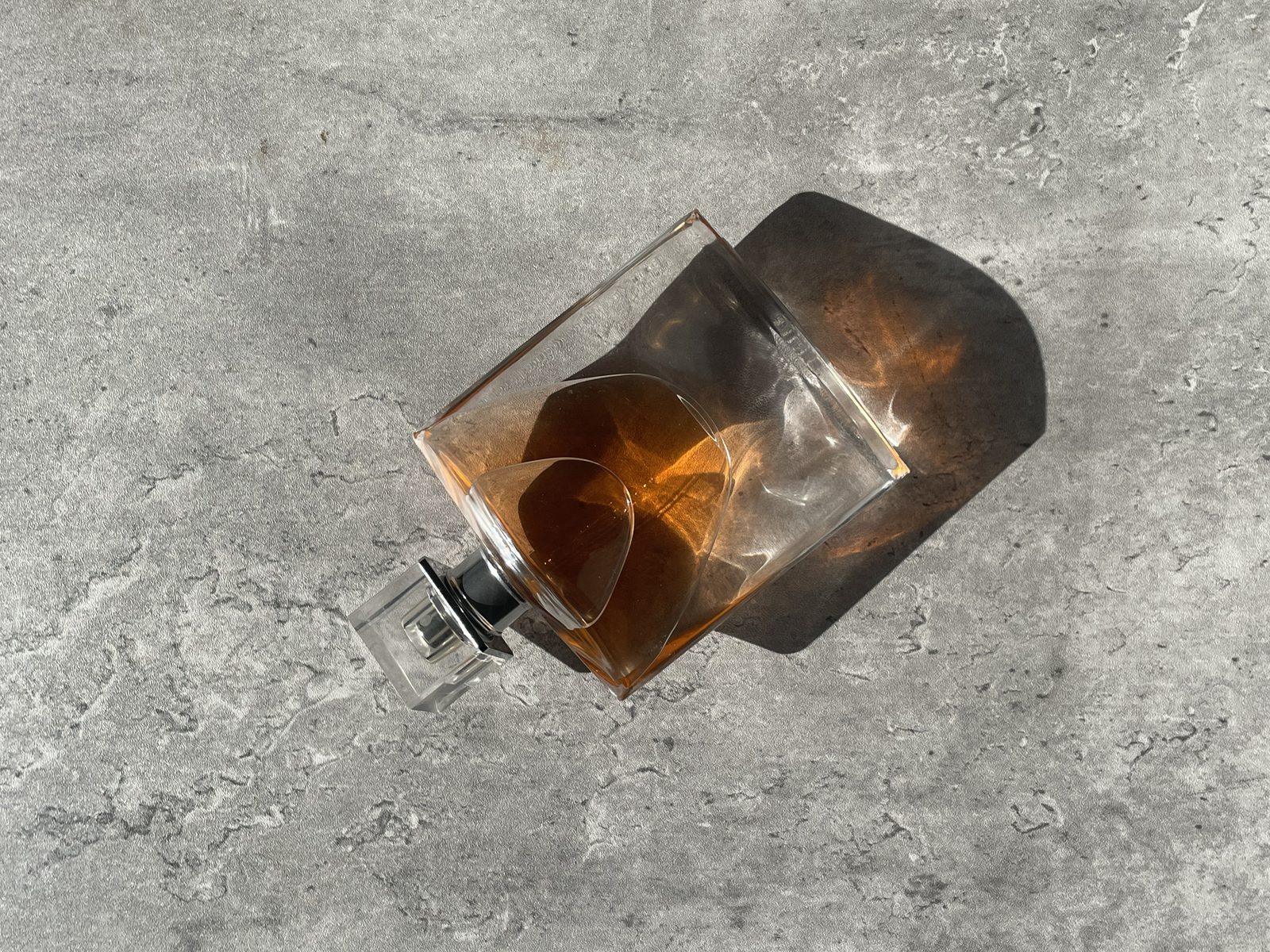 Lancome La Vie Est Belle: Honest Review Lancome La Vie Est Belle bottle shot from above on grey concrete