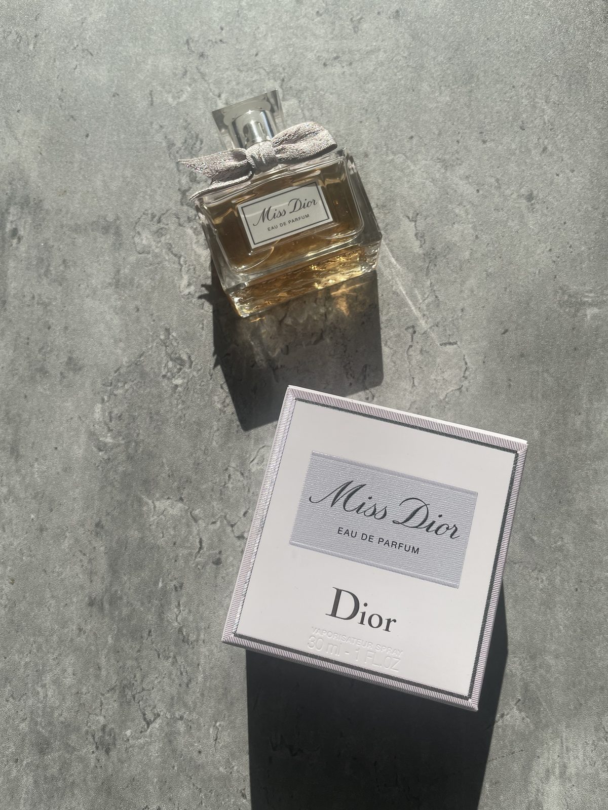 Miss Dior Perfume: The Modern and Airy Fragrance Reviewed Miss Dior Eau de Parfum 30ml bottle and box on sunlit concrete