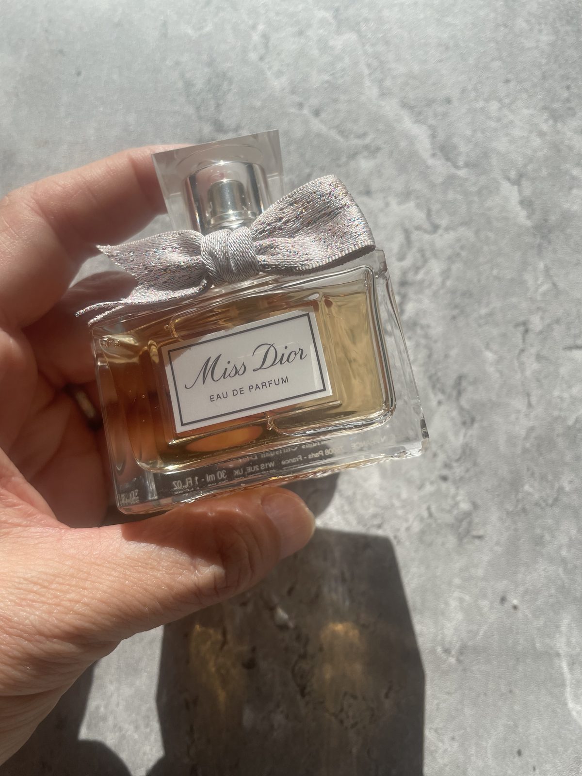 Miss Dior Perfume: The Modern and Airy Fragrance Reviewed Holding the Miss Dior Eau de Parfum 30ml bottle with the cap and bow on