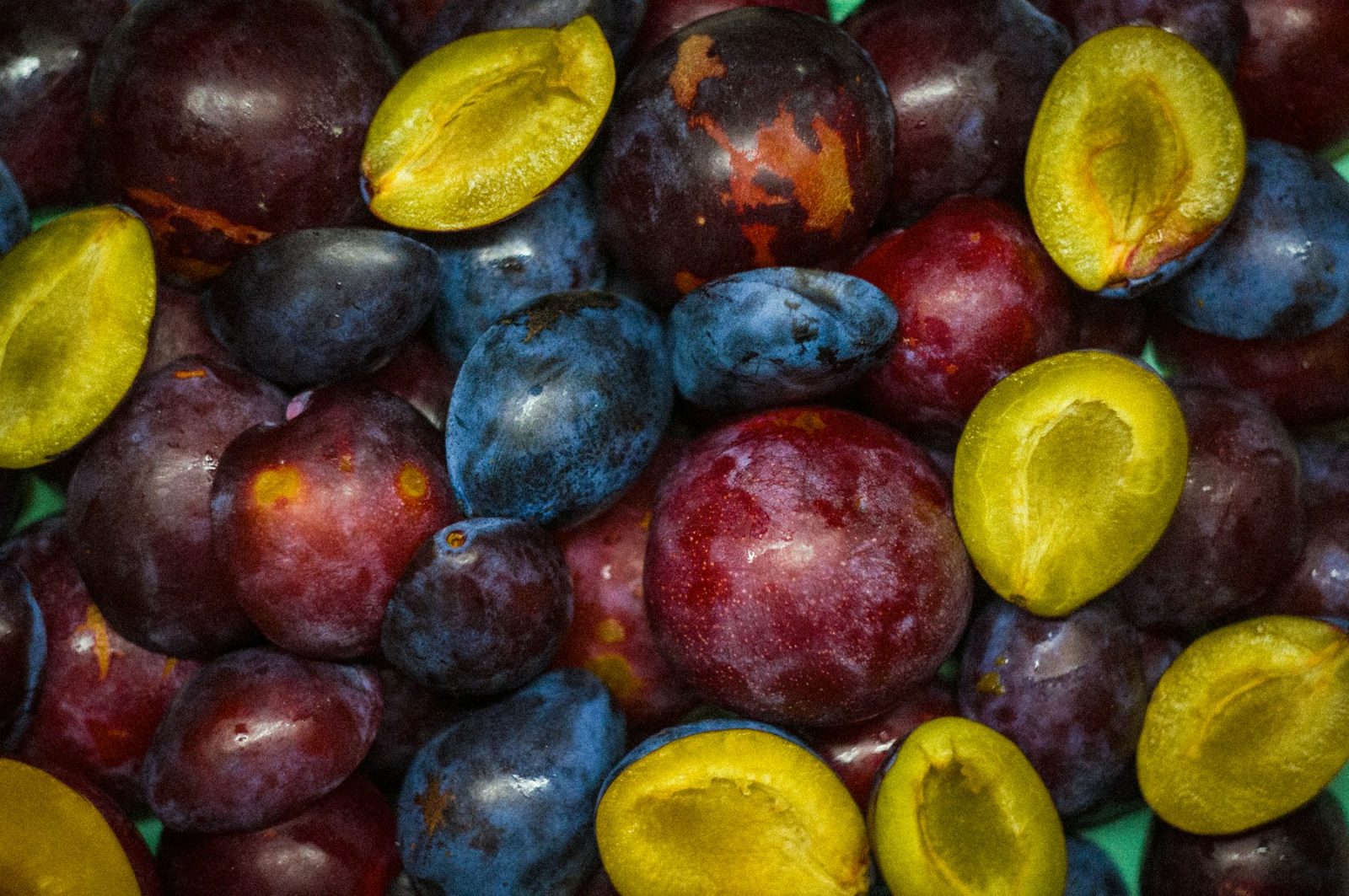 What Does Plum Smell Like? Plums halved to show the deep flesh and stone