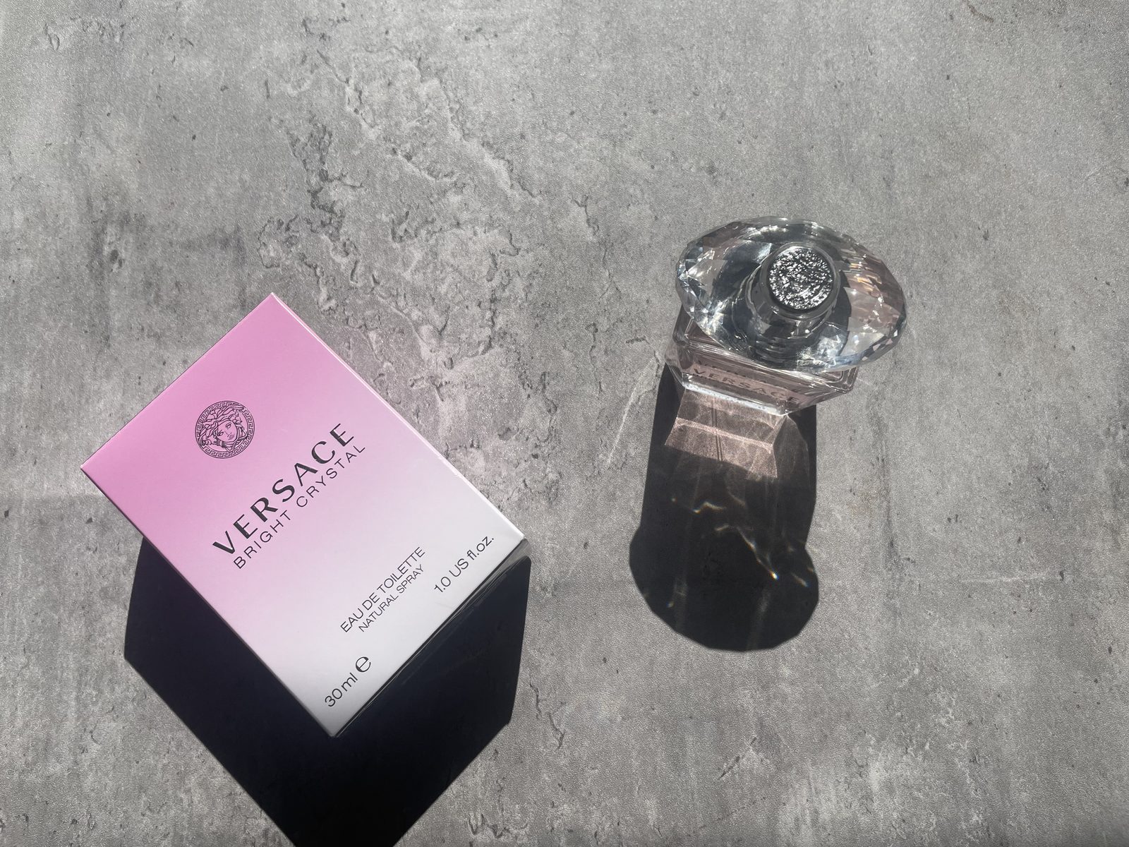 What Does Versace Bright Crystal Smell Like? Versace Bright Crystal Eau de Toilette 30ml bottle and box on sunlit concrete